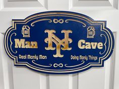 a blue and gold man cave sign on a white door