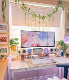 a desk with a computer, speakers and plants on it in front of a window