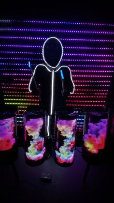 a person is standing in front of some speakers with lights on them and an image of a man's face