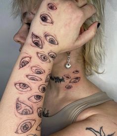 a woman with many different tattoos on her arm and shoulder, both showing their eyes