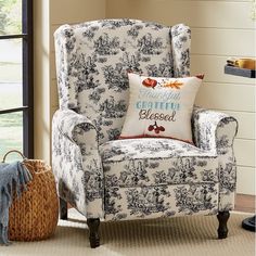 a blue and white chair sitting in front of a window with a pillow on it