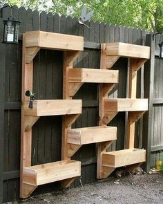 a wooden book shelf sitting next to a fence