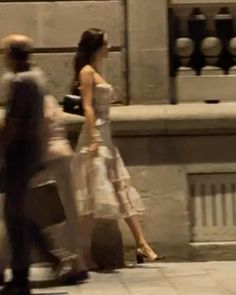 a man and woman walking down the street with luggage