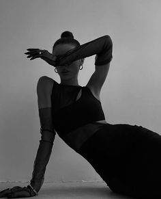 black and white photograph of a woman in tight clothing with her hands behind her head