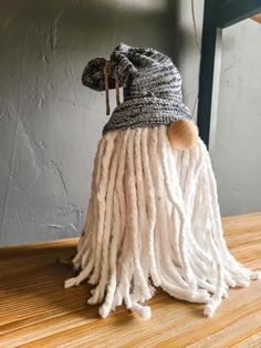 a white and black hat with long hair on top of a wooden table