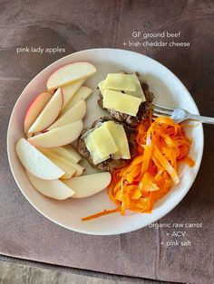 an apple, carrots, and cheese plate on a white plate with a fork