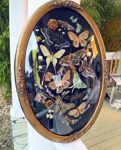 there are many butterflies in the glass on this wall hanging by the porch railings