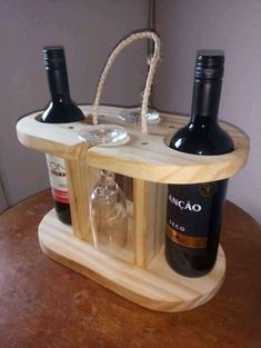 two wine bottles are sitting in a wooden holder