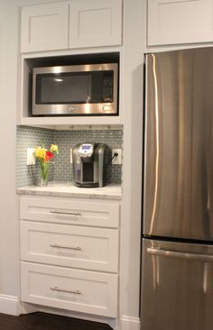 a stainless steel refrigerator freezer sitting next to a microwave oven on top of a counter