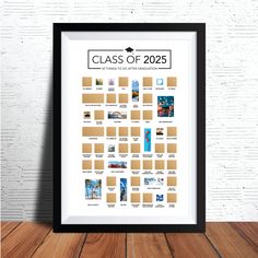 the class of 205 poster is displayed on a wooden table next to a white brick wall