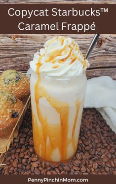 an iced drink with whipped cream and caramel drizzle on top next to muffins