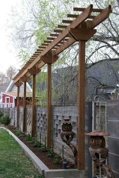 a wooden pergolan sitting on top of a lush green field next to a fence