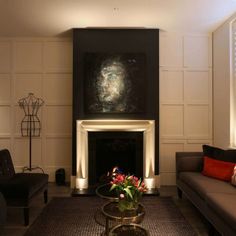 a living room filled with furniture and a fire place in front of a painting on the wall