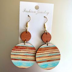 wooden earrings with multicolored circles hanging from hooks on a white cardboard background