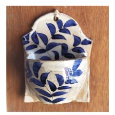 a blue and white bowl sitting on top of a wooden table next to a wall