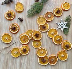 orange slices cut in half on a table with pine cones, cinnamon sticks and star anise