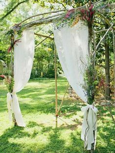 an outdoor wedding ceremony with white draping and greenery