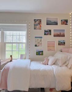 a bedroom with pictures on the wall above the bed and lights hanging from the ceiling