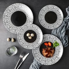 three plates with meat and vegetables on them next to silverware, forks and spoons