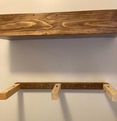 two wooden shelves are hanging on the wall