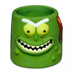 a green monster mug with big eyes and fangs on it's face is shown