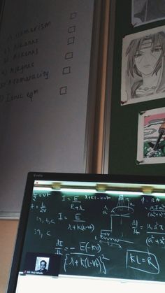 a blackboard with some writing on it next to a wall covered in pictures and drawings