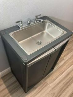 a stainless steel sink in the corner of a room