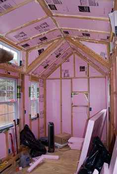 the inside of a house with pink walls and wood framing on the ceiling is being built