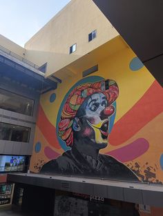 a large mural on the side of a building with a woman's face painted on it