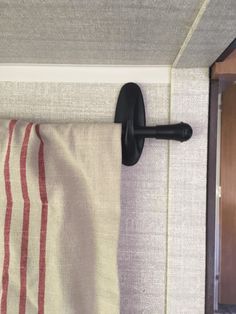 a towel hanging on the side of a wall next to a door with a curtain