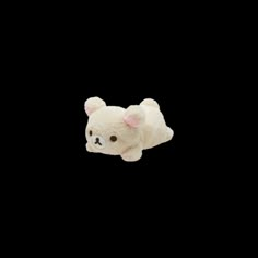 a small white teddy bear floating in the air