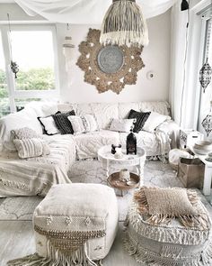 a living room filled with white furniture and lots of pillows on top of it's covers