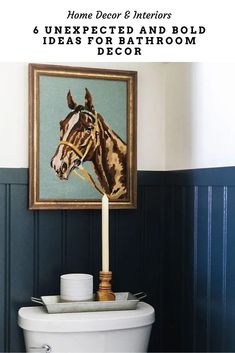 a white toilet sitting in a bathroom next to a framed horse head on the wall