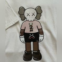 Size Medium Kaws T-Shirt. Never Worn But Good Condition White Short Sleeve Top With Cartoon Print, White Casual Top With Cartoon Print, Casual White Tops With Cartoon Print, White Crew Neck Top With Front Print, White Front Print Top For Streetwear, White Graphic Tee With Cartoon Print, White Cartoon Print Graphic Tee, White Casual T-shirt With Cartoon Print, Casual White T-shirt With Cartoon Print