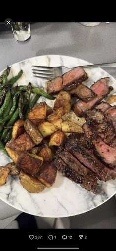 steak, potatoes and green beans on a white plate with a silver fork next to it