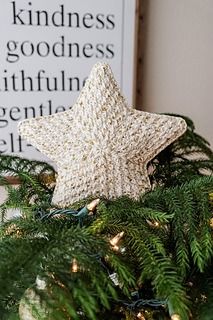 a star ornament sitting on top of a christmas tree