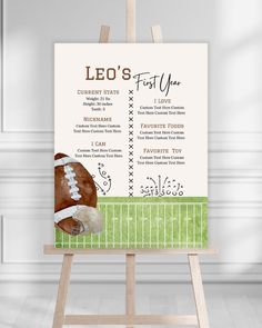 a football themed baby's first year poster on an easel in a room