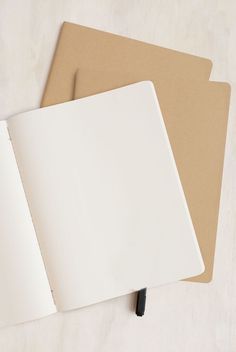 two blank notebooks sitting on top of each other