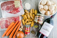 meat, potatoes, carrots, and other ingredients are laid out on a table