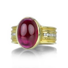 An 18k yellow gold ring featuring an oval rubellite tourmaline cabochon center stone totaling 8.1cts on a 7.7mm shank channel-set with diamonds totaling 0.46cts. Stone measures 3/8" x 1/2". Size 7. Handcrafted in Rochester, NY, U.S. Anthony Lent, Rubellite Tourmaline, Ring With Diamond, 18k Yellow Gold Ring, Rochester Ny, Tourmaline Ring, Channel Set, Diamond Gemstone, Yellow Gold Rings