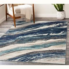 a blue and white area rug with waves on the floor in front of a chair