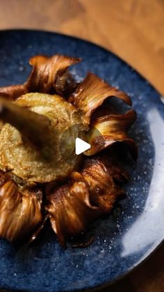 a blue plate topped with food on top of a wooden table