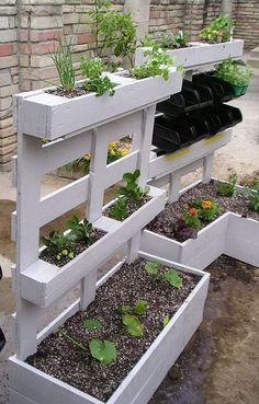 an outdoor planter made out of pallets with plants growing in the top and bottom