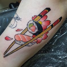 a tattoo with sushi and chopsticks on it