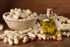 a bottle of cashew oil next to peanuts