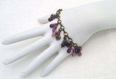 Purple Beaded Cluster Bracelet 7", with chain extension to 8", made with glass beads, antique gold-layered beads, brass beads, chain, and lobster clasp. This Purple Beaded Cluster Bracelet will ship to you in a gift box, securely mailed in a padded envelope. Shipping same or next day, thru USPS Ground Advantage, tracking and insurance included. Once mailed, you can track your package at USPS.com. If you don’t love your new treasure, you have 30 days to return it. Back to Bracelets. Purple Bead Necklace, Cluster Bracelet, Wearable Art Jewelry, Cluster Bracelets, Beads Chain, T Love, Long Drop Earrings, Cluster Necklace, Beaded Accessories