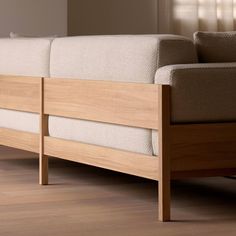 a wooden bed frame sitting on top of a hard wood floor next to a window