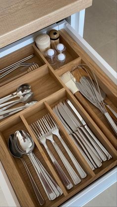 an open drawer with silverware and utensils