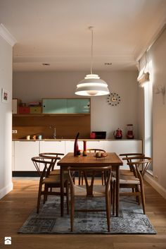 a dining room table and chairs in front of an open kitchen