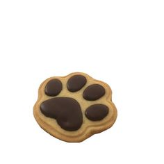 a dog paw cookie with chocolate icing on it's side, against a white background